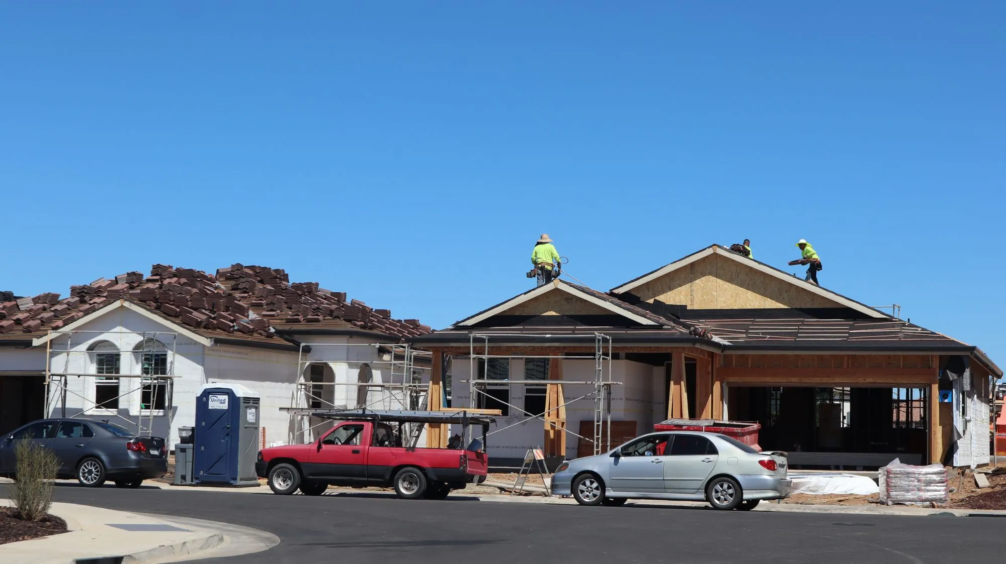 A completed asphalt shingle roof on a two-storey house