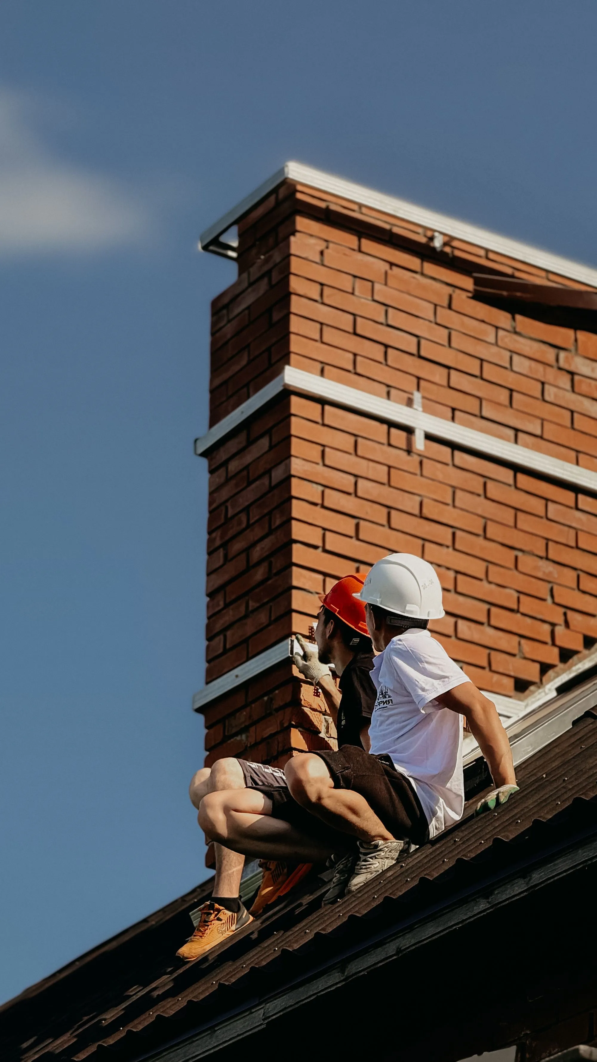A roofer examining the surface of a residential roof slope