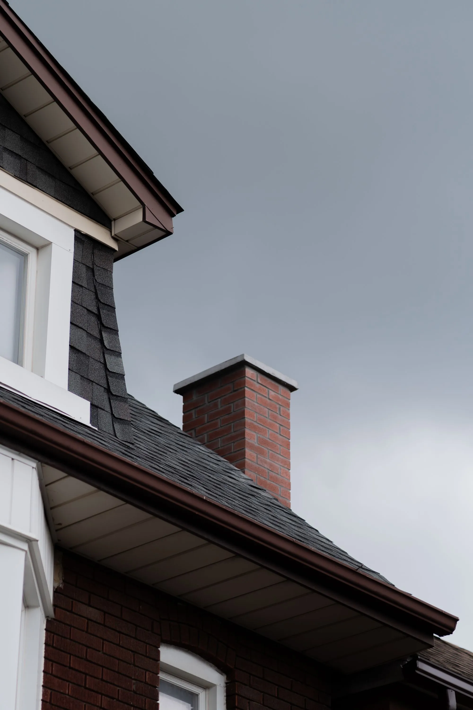A completed shingle roof on a residential property surrounded by trees